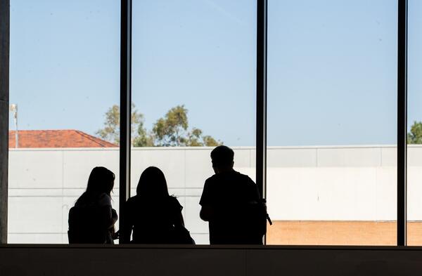 student shadows against windows